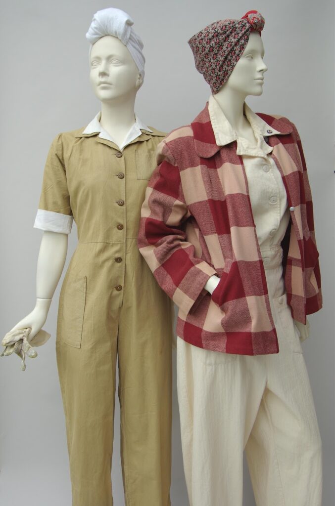 2 mannequins dressed in military inspired overalls with neutral under shirts and turban scarves