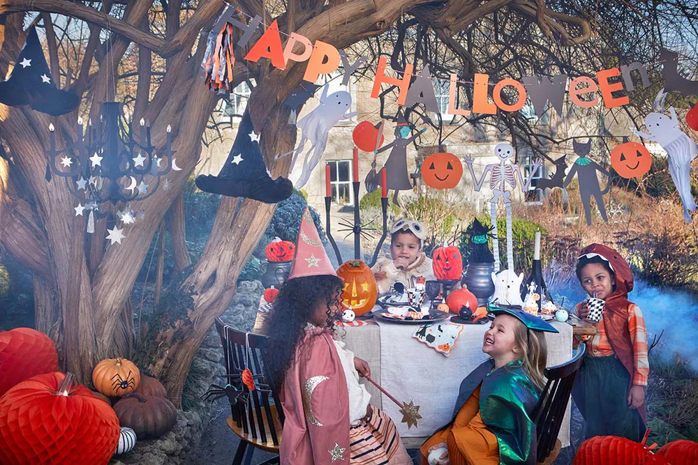 Kids enjoying a happy halloween garden party outdoors