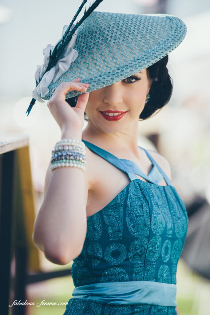 Lady in aqua blue sleeveless dress with satin trim and vietnamese looking adorned straw hat