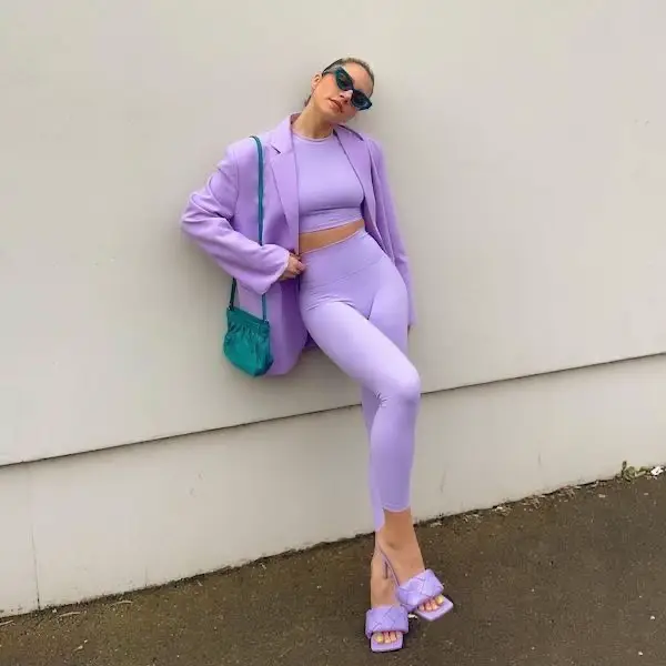 Lady in sporty athleisure top and pants teamed with matching violet blazer