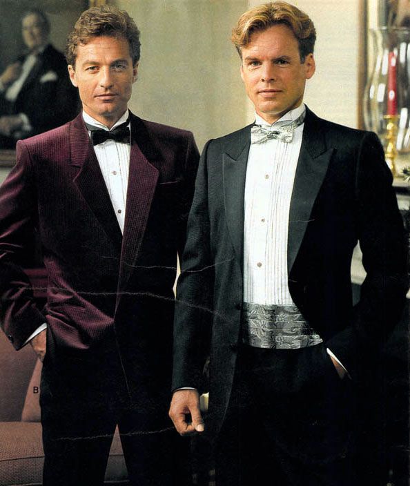 two men in single breasted suits and formal shirts with cumberbund matching the bow tie