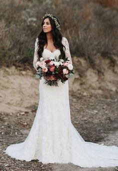 Boho bride with long sleeved lace dress and train and hair extended in soft waves with floral tiara