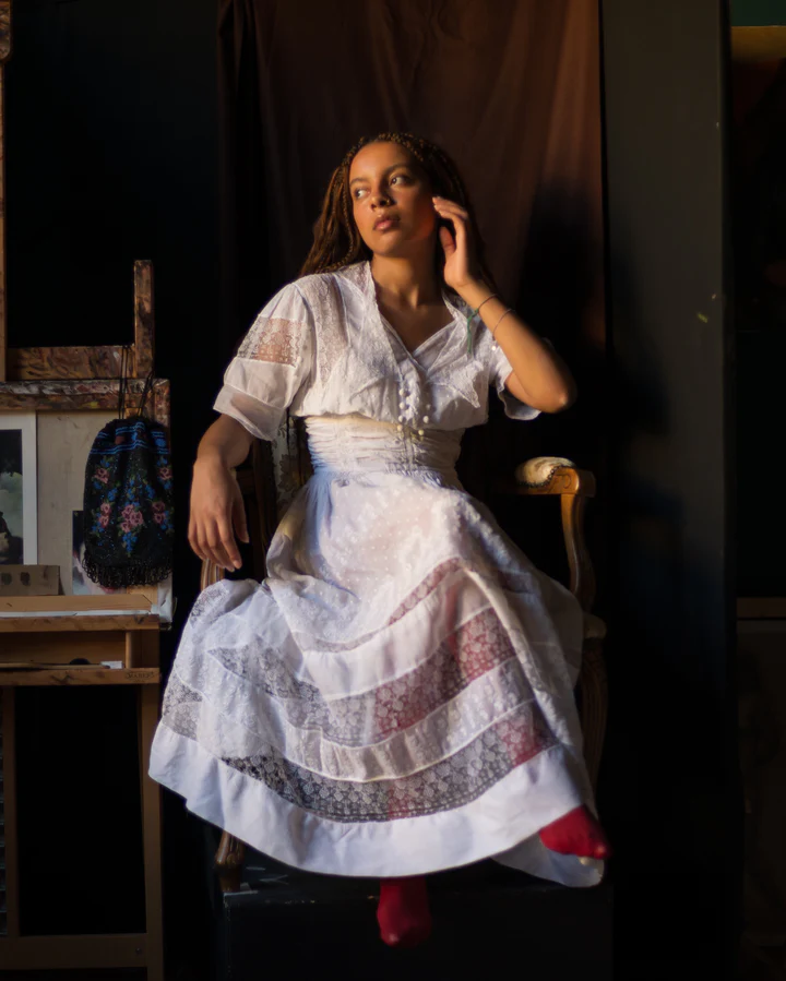 Girl wearing a white 1910's organdy and lace dress