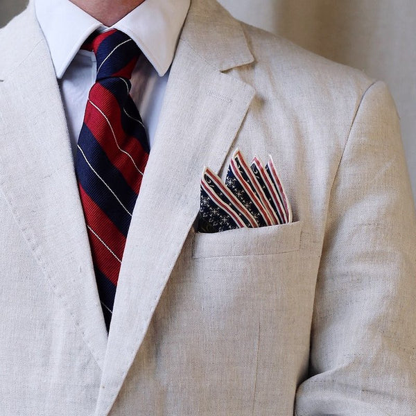 Man's tie and pocket square to contrast light suit