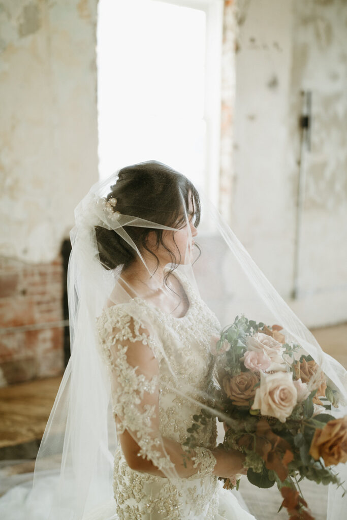 Woman with a soft tulle veil and a full lace wedding dress