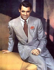 Cary Grant in a double breasted grey suit brown tie and red carnation