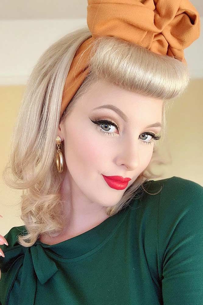 blonde lady with 1950's waves and bangs over forehead wearing a scalf on top of her hair