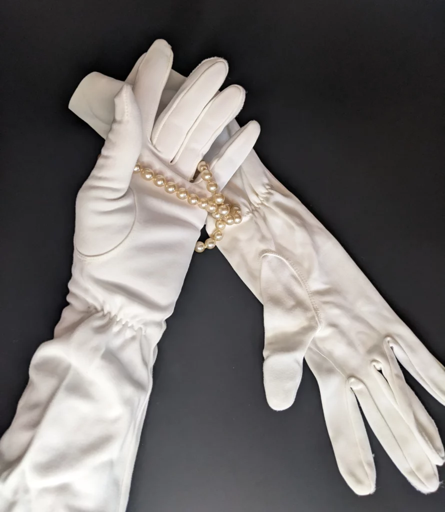 Ladies formal long white antique gloves holding pearls