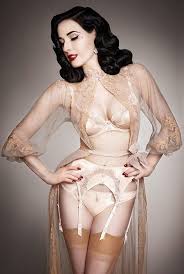 Actress Dita Von Teese dressed in 50's lingerie ensemble of suspenders and stockings under a sheer dressing gown