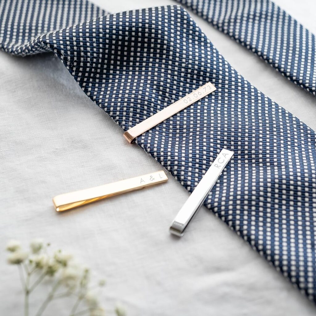 Assorted tie clips on a spotted blue tie