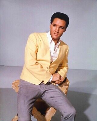 Elvis Presley sitting on a stool in yellow casual jacket and contrast pants