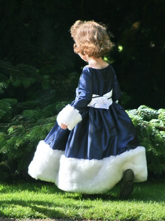 Girl in deep blue taffeta long sleeve dress with wide faux fur trims in white