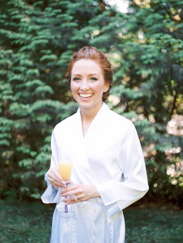 lady in a white robe holding a champagne glass