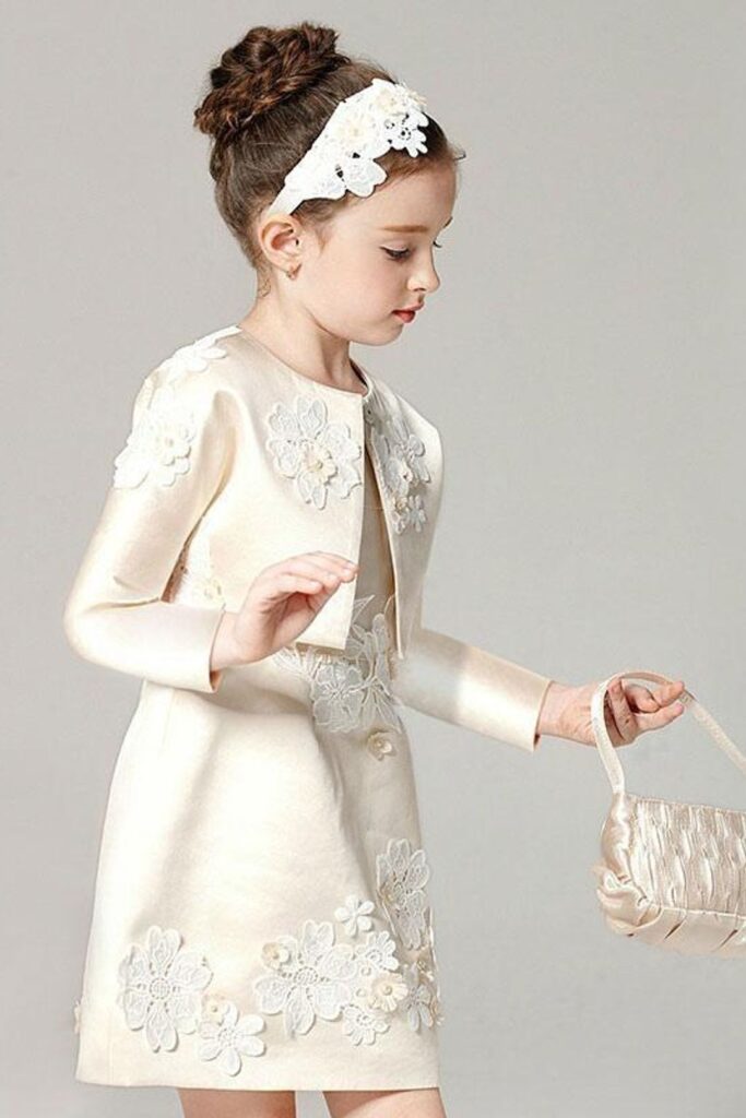 Flower girl in a vintage inspired 2 piece ivory dress and bolero with applique on both and headpiece