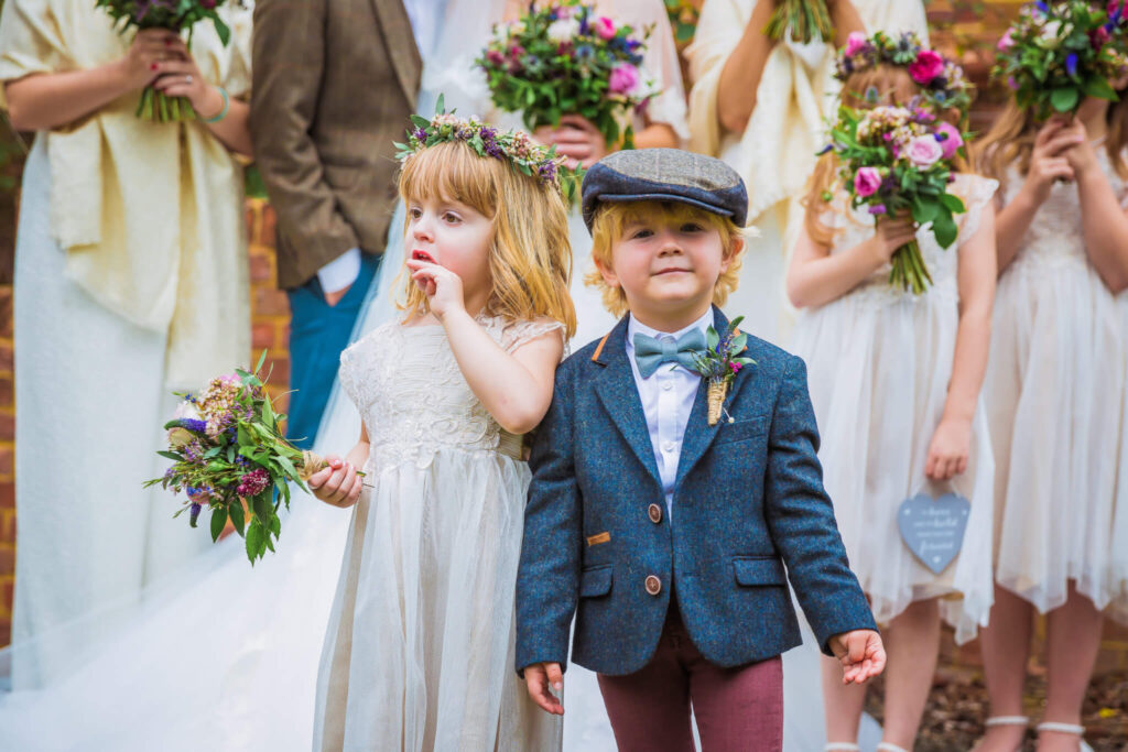 little girl and boy in vintage inspired 1930's dress as flower girl and page boy sporting the same flower garland and button hole in their outfits