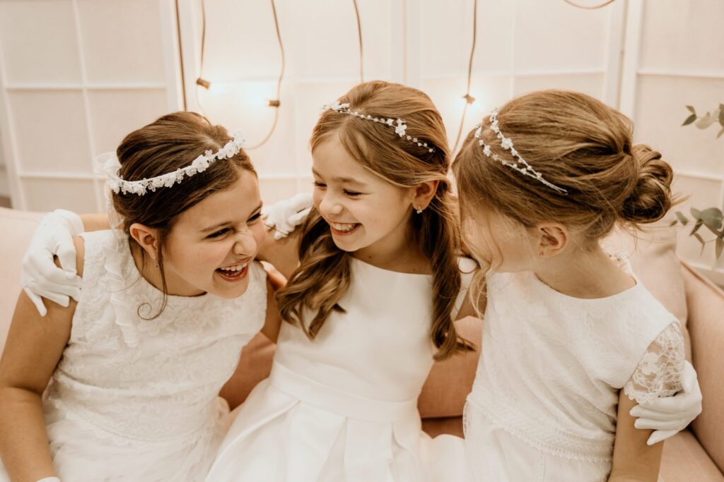 3 girls with dainty flower hair garlands in round neck white dresses in the same white tones