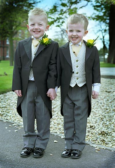 2 blonde boys in tail suits with striped pants and beige waistcoats and gold ties