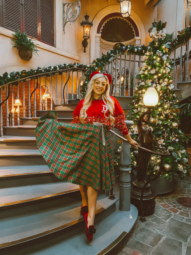 lady standing on a old stairwell in a tartan skirt and red top