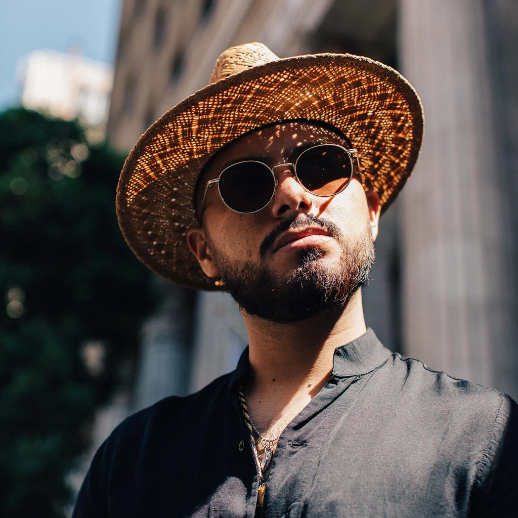 man wearing sunglasses and a straw fedora hat