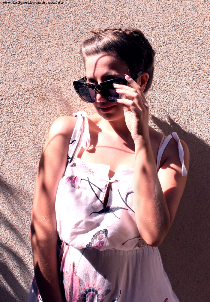 lady in a sleeveless dress with hair up and sunglasses on