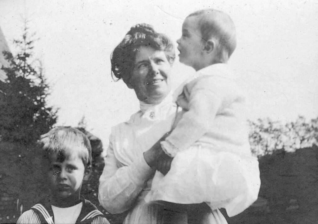 Mother holding daughter with son next to her - edwardian era