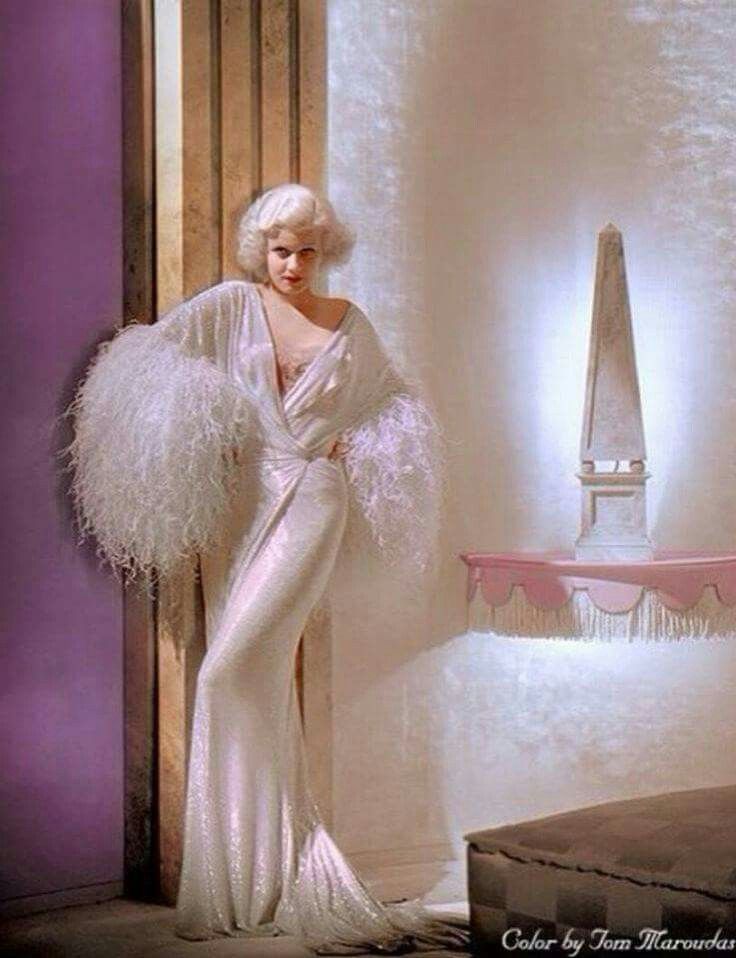 1950's woman in a long house gown with feather trims on sleeves
