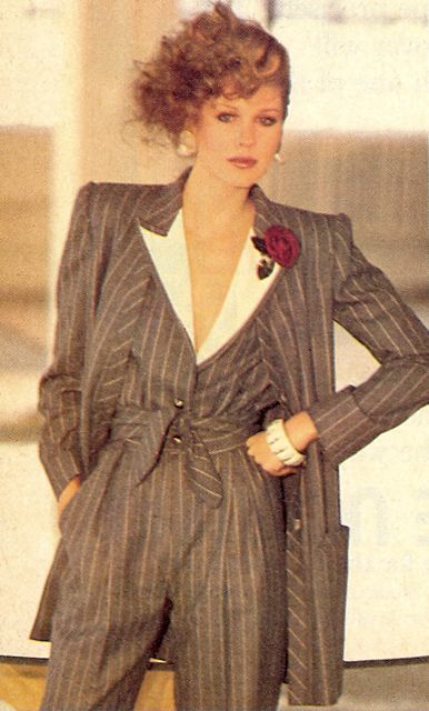 Lady dressed in 3 piece pants suit with collared waist coat and adornment