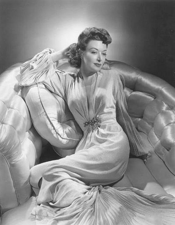 1940's Dorothy Day in a long satin pleated gown with clasp on waistline