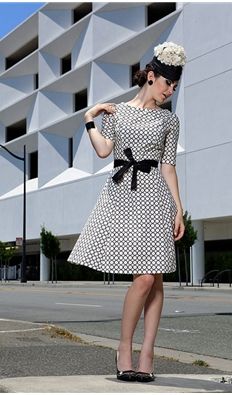 Girl in a tweed dress with black accessories and fascinator hat