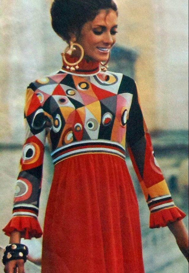 lady wearing 2 toned dress with bodice in geometric shapes and a plain red skirt in lower end