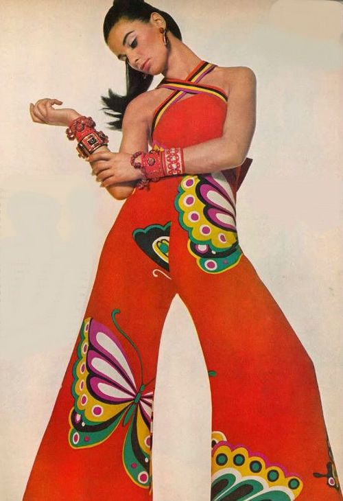 Lady modelling a halter jumpsuit with cross bodice and butterfly design throughout