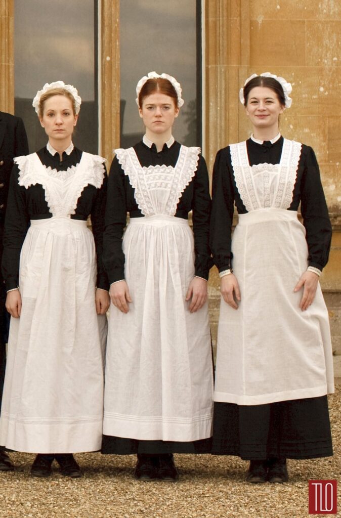 3 housemaids in their long black dresses and long white  aprons with hair cuff bands
