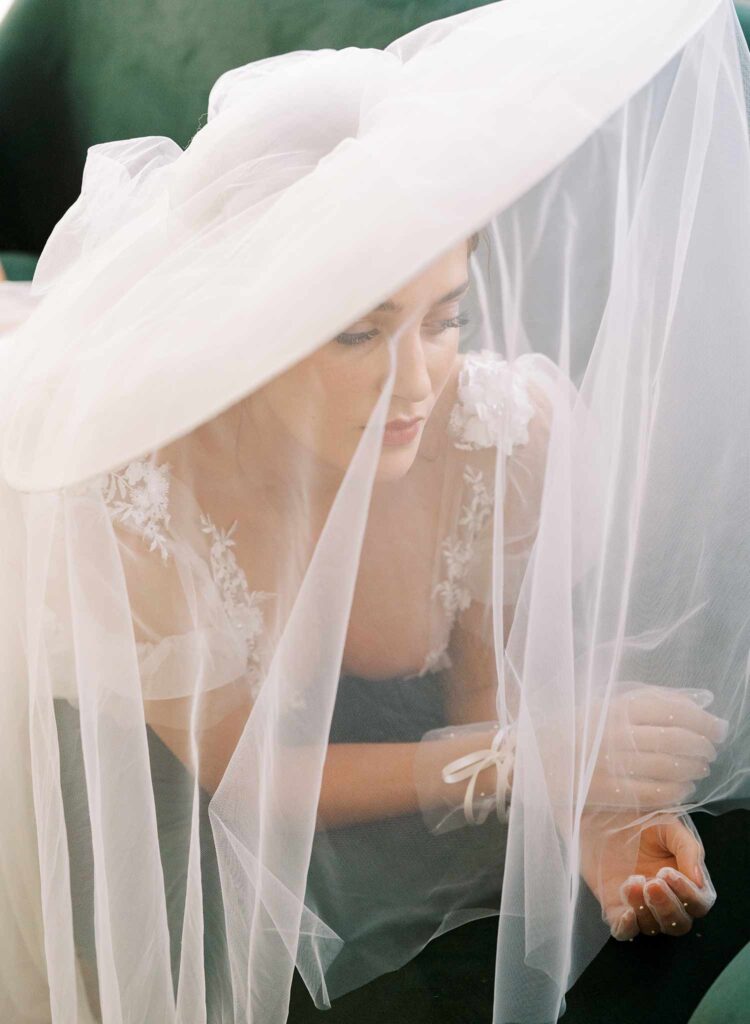 lady with wide brim veil hat and wedding dress