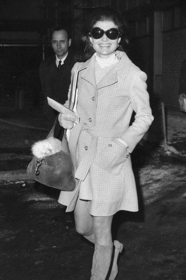 Jackie O with her favouite handbag matching suede boots amd a trench coat