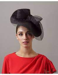 lady in a black fascinator hat and a red top