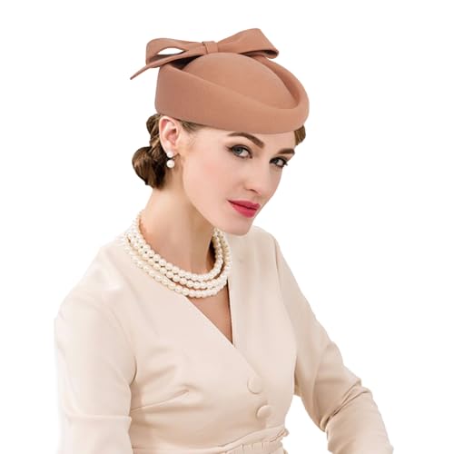 lady wearing beige pill box hat and a cream suit with pearls